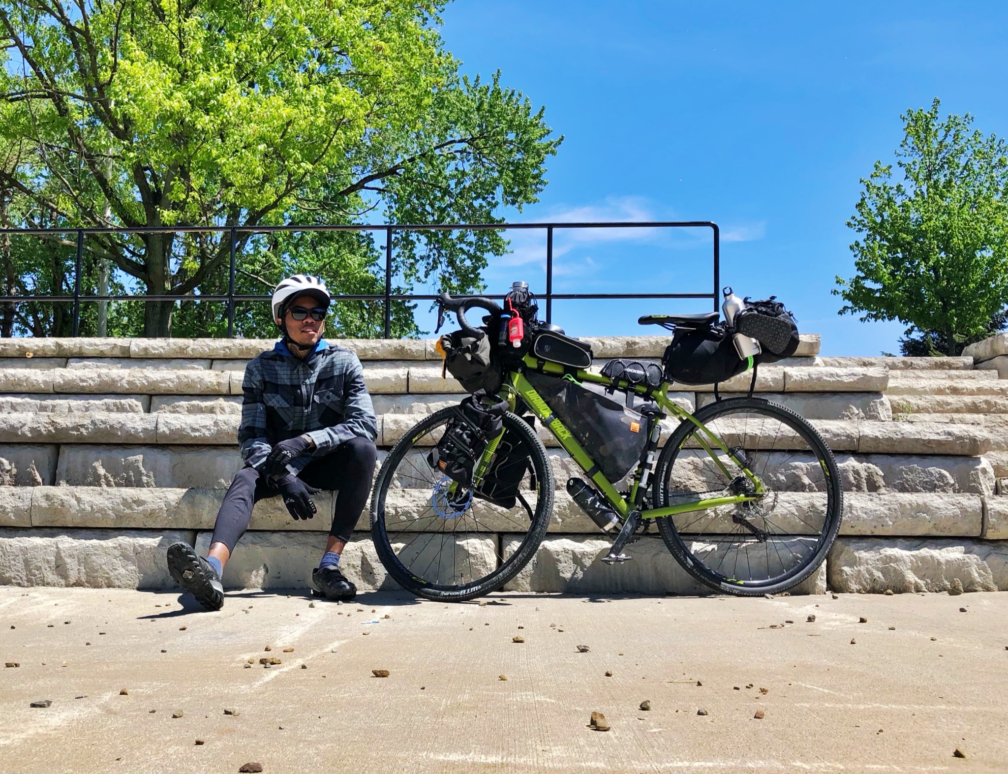 Man sits next to bike during bikepacking trip