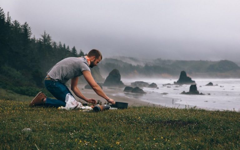 Man cooks food next to beach