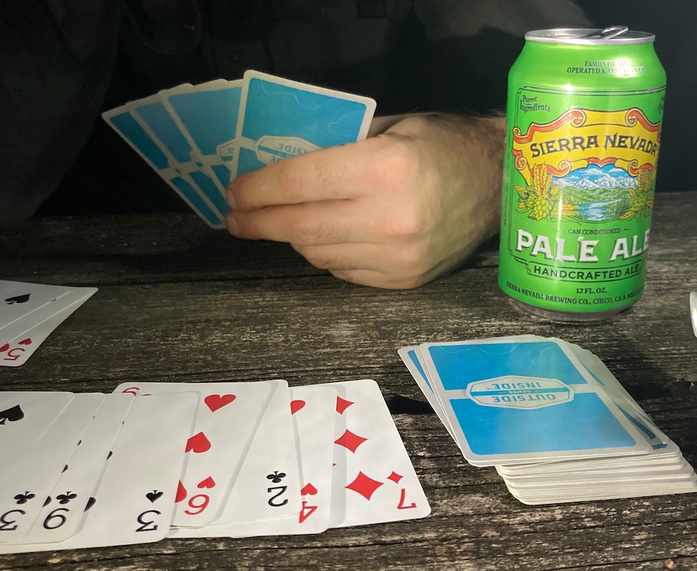 Beer on table next to playing cards
