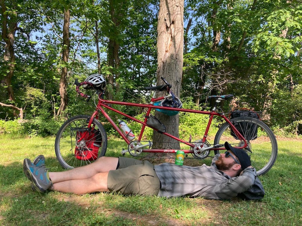 Man lies on ground next to tandem bike